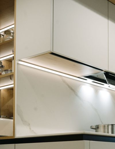 mujer haciendo café en desayunador de cocina blanca