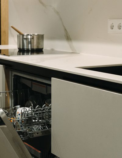 mujer abriendo lavavajillas lavaplatos integrado