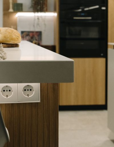 detalle de enchufes en isla de cocina blanca con palillería