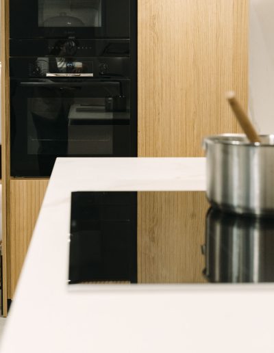 vista de electrodomésticos negros en cocina blanca con palillería