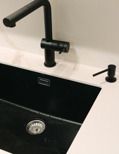 grifo y fregadero negros a juego con fregadero bajoencimera en cocina blanca